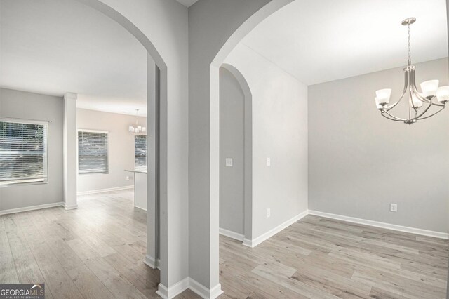 458 Ajo Way, Dallas, GA 30157 - hall with a chandelier, light wood-type flooring, and arched walkways