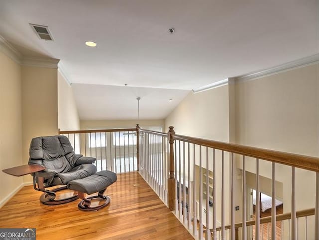 sitting room with wood finished floors, crown molding, baseboards, and recessed lighting