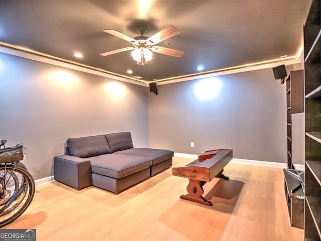 cinema room featuring ceiling fan, recessed lighting, wood finished floors, crown molding, and baseboards
