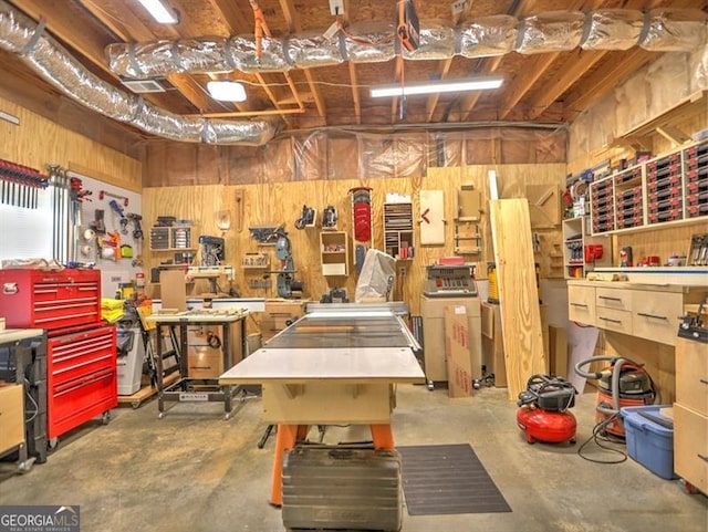 garage featuring a workshop area and wood walls