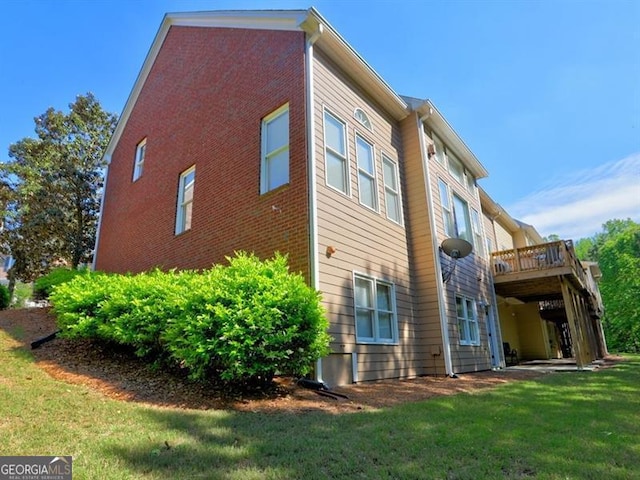 rear view of property with a lawn and a deck