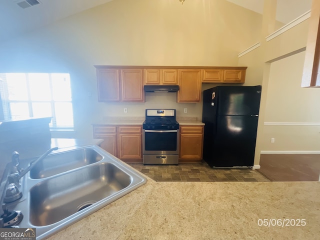 kitchen with freestanding refrigerator, stainless steel range oven, a sink, high vaulted ceiling, and light countertops