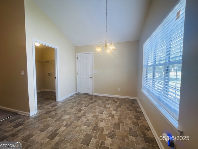 unfurnished dining area with lofted ceiling, a chandelier, and baseboards