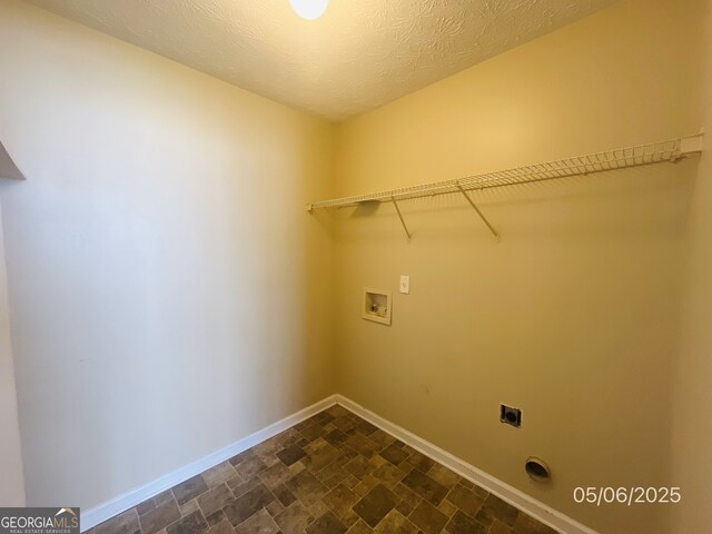 clothes washing area featuring electric dryer hookup, hookup for a washing machine, baseboards, and stone finish floors