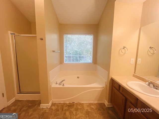 bathroom featuring a shower stall, vanity, and a garden tub
