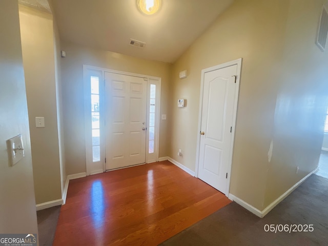 entrance foyer featuring wood finished floors, baseboards, and lofted ceiling