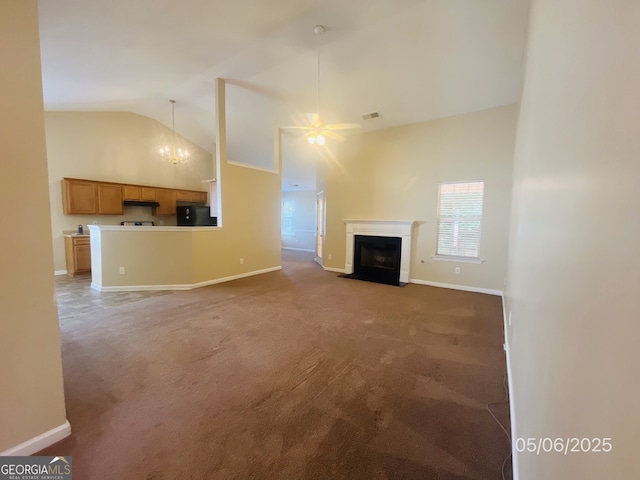 unfurnished living room featuring carpet floors, a fireplace with flush hearth, healthy amount of natural light, high vaulted ceiling, and a ceiling fan