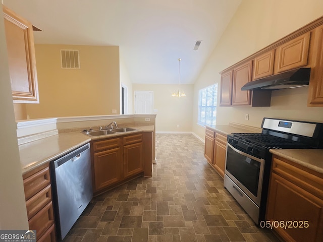 kitchen with stainless steel appliances, under cabinet range hood, a sink, a chandelier, and vaulted ceiling