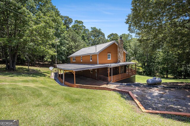 1795 Hutcheson Ferry Rd, Whitesburg, GA 30185 - rear view of property featuring a chimney, a lawn, and view of scattered trees