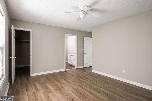 175 Hearth Way, Fairburn, GA 30213 - unfurnished bedroom featuring a walk in closet, wood finished floors, baseboards, a closet, and connected bathroom