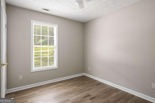 175 Hearth Way, Fairburn, GA 30213 - unfurnished room featuring wood finished floors, healthy amount of natural light, baseboards, and a textured ceiling