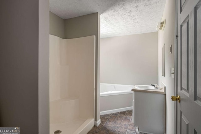 175 Hearth Way, Fairburn, GA 30213 - bathroom featuring a textured ceiling, a stall shower, a bath, baseboards, and vanity