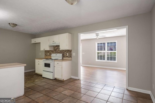 175 Hearth Way, Fairburn, GA 30213 - kitchen with white electric range oven, under cabinet range hood, backsplash, white cabinets, and baseboards