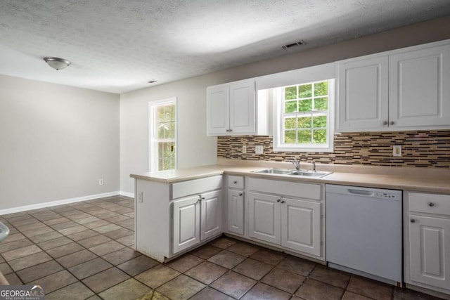 175 Hearth Way, Fairburn, GA 30213 - kitchen with white dishwasher, a sink, backsplash, a peninsula, and a textured ceiling