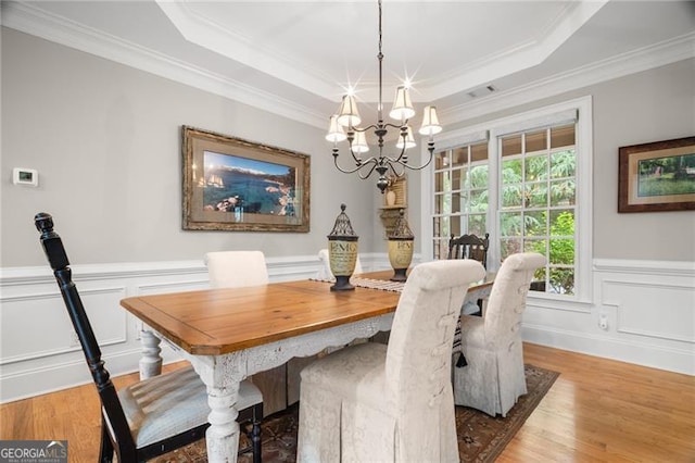 15 Sconti Knoll Dr, Jasper, GA 30143 - dining space featuring a chandelier, ornamental molding, light wood-type flooring, a tray ceiling, and a wainscoted wall