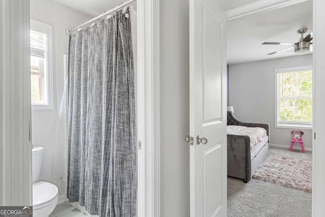 full bathroom featuring ceiling fan, toilet, a shower with curtain, and baseboards