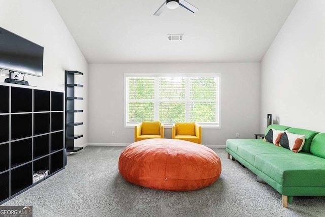 sitting room with carpet flooring, vaulted ceiling, baseboards, and ceiling fan