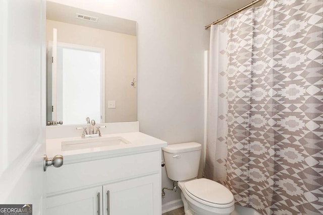 bathroom featuring toilet, vanity, and curtained shower