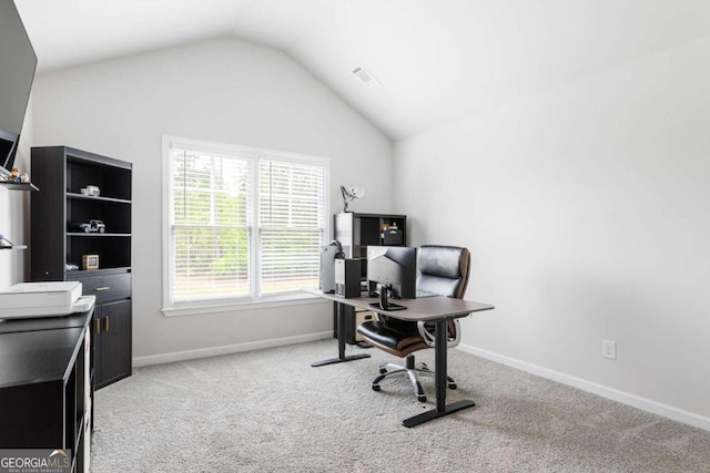 office featuring vaulted ceiling, light colored carpet, and baseboards