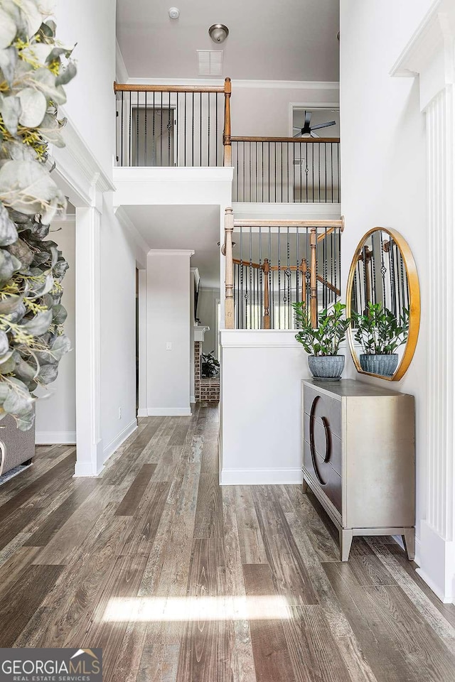 foyer with ceiling fan, wood finished floors, and crown molding