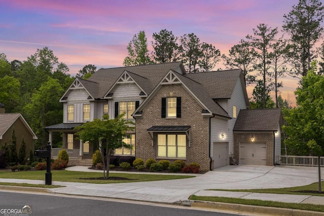 craftsman house with driveway, brick siding, a garage, roof with shingles, and a yard