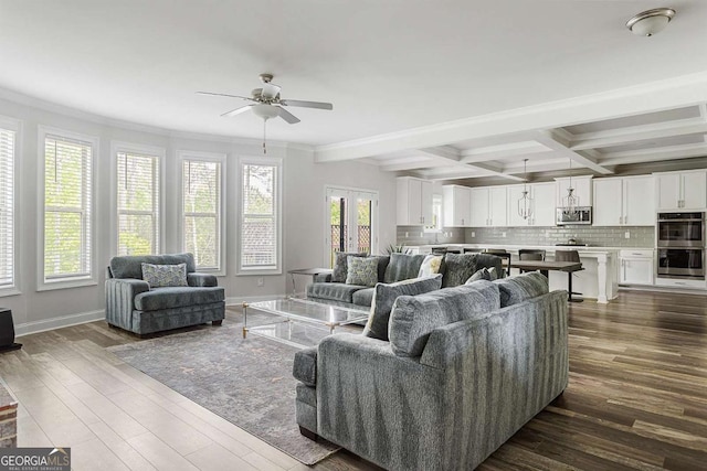 living area featuring ceiling fan, dark wood-type flooring, beamed ceiling, crown molding, and coffered ceiling