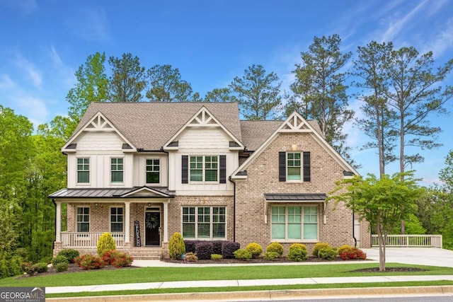 craftsman-style home featuring covered porch, brick siding, and a front lawn