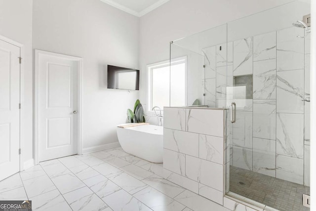 bathroom featuring marble finish flooring, a shower stall, a soaking tub, crown molding, and baseboards