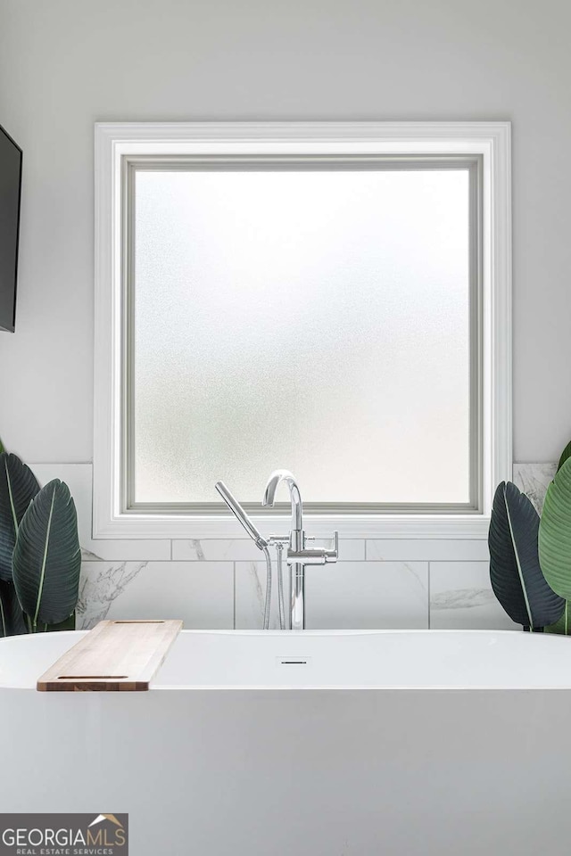 bathroom view of a soaking tub and a sink