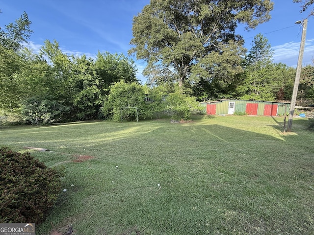 view of grassy yard with an outdoor structure and an outbuilding