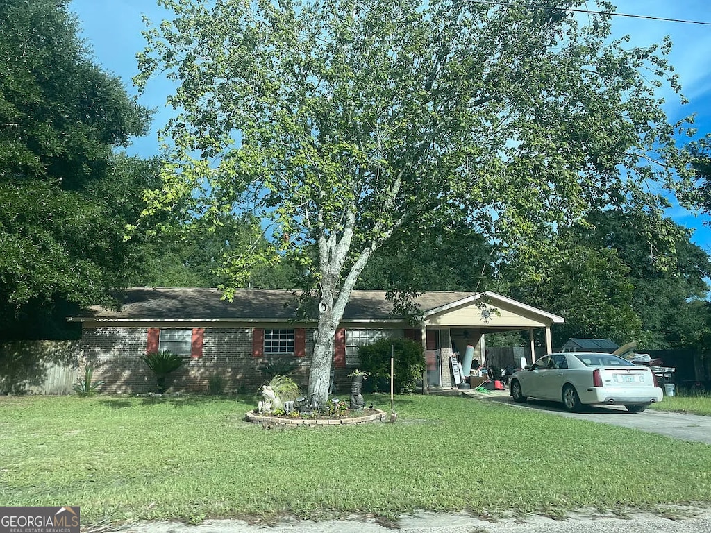 view of front of house featuring a front yard, concrete driveway, and an attached carport