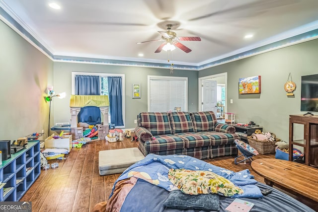 living room with a ceiling fan, wood-type flooring, ornamental molding, and recessed lighting