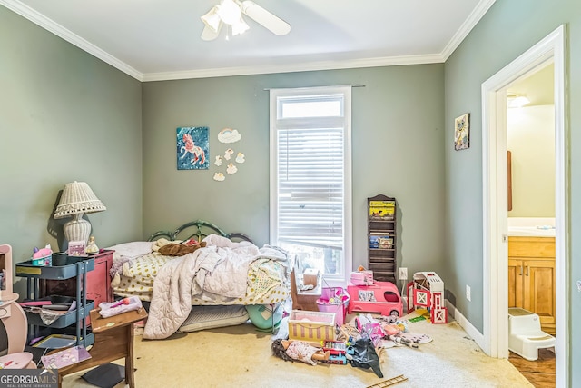 bedroom featuring crown molding, carpet floors, ensuite bathroom, and a ceiling fan