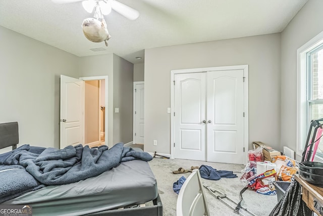 bedroom with a closet, carpet, a textured ceiling, and baseboards