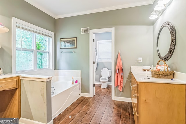 bathroom with vanity, wood finished floors, toilet, a bath, and baseboards