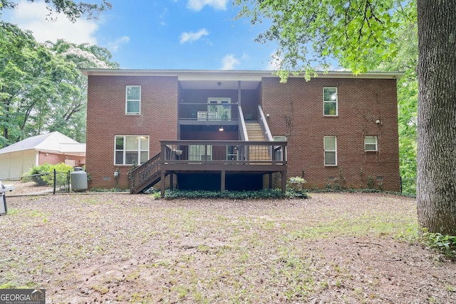 back of house with stairs, brick siding, fence, and a wooden deck