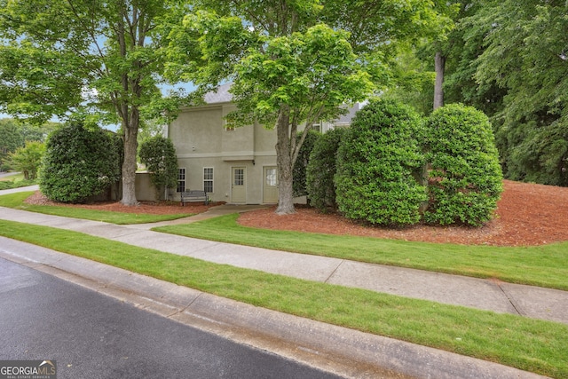 132 Eagles Club Dr, Stockbridge, GA 30281 - obstructed view of property featuring stucco siding and a front lawn
