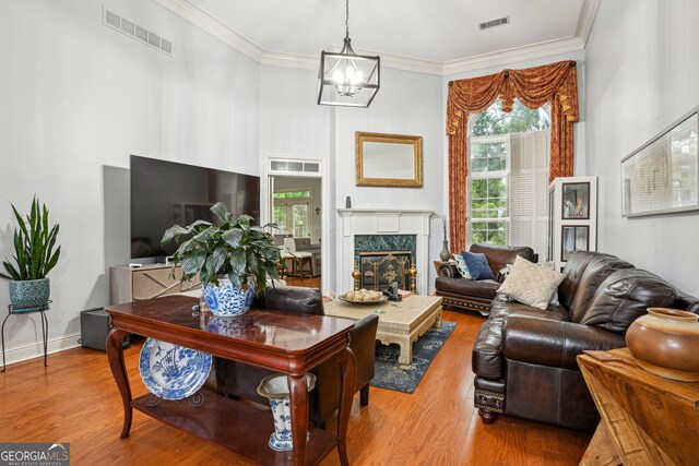 132 Eagles Club Dr, Stockbridge, GA 30281 - living area featuring wood finished floors, crown molding, a chandelier, a towering ceiling, and a fireplace