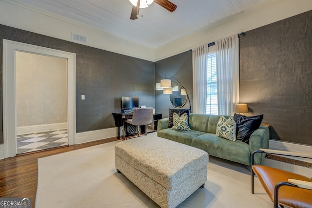 living area featuring wood finished floors, ceiling fan, a desk, and ornamental molding
