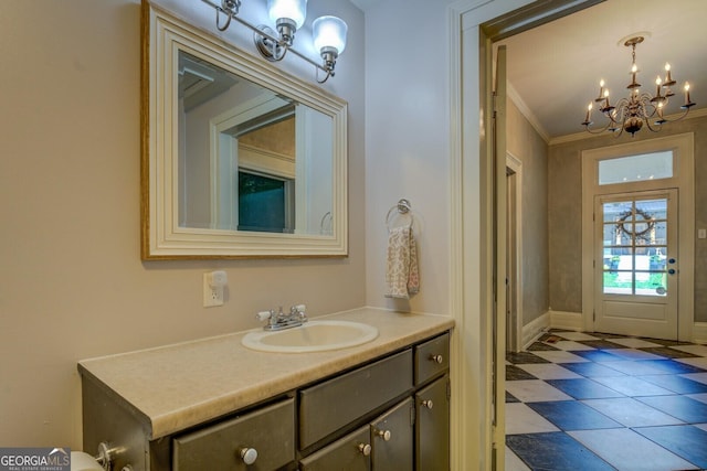 bathroom with a chandelier, vanity, crown molding, tile patterned flooring, and baseboards