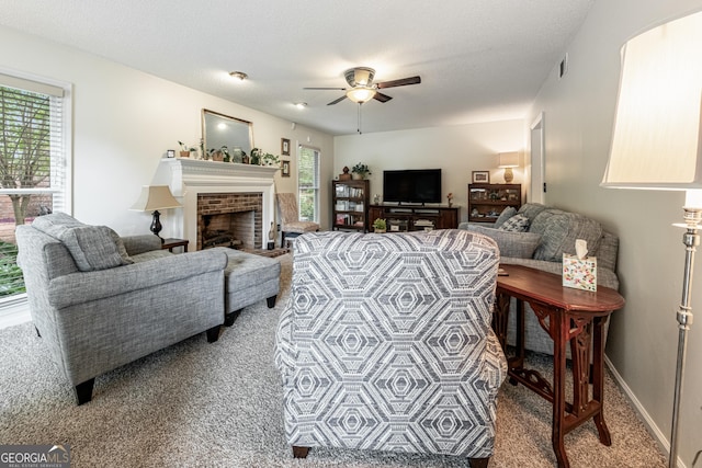 living room featuring carpet flooring, a ceiling fan, a fireplace, and baseboards