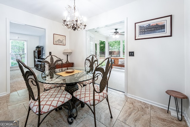 dining area featuring baseboards, a chandelier, ceiling fan, and light carpet