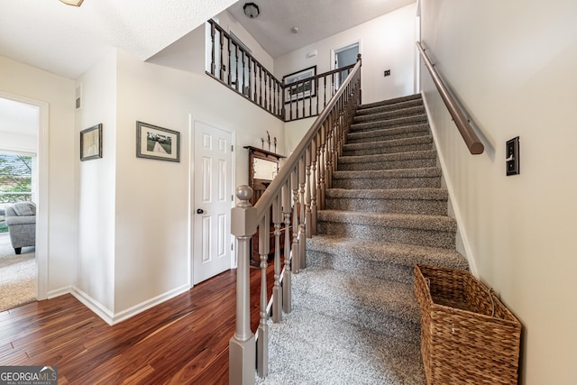 stairs with wood finished floors and baseboards
