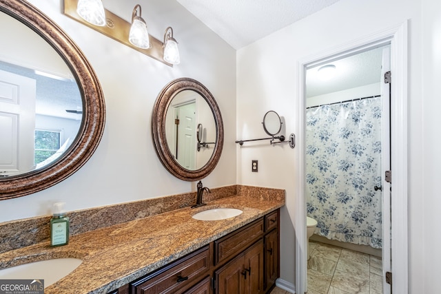 full bathroom with double vanity, toilet, a textured ceiling, and a shower with curtain