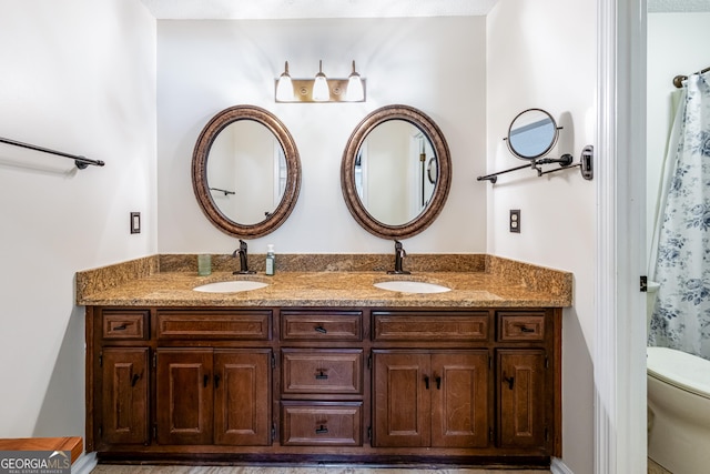 full bathroom with toilet and double vanity