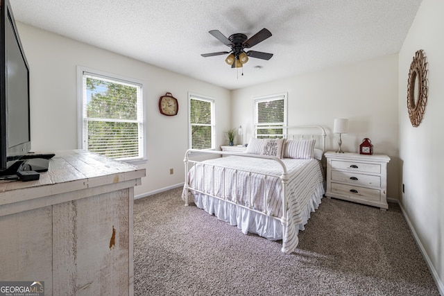 bedroom with a textured ceiling, carpet floors, baseboards, and ceiling fan
