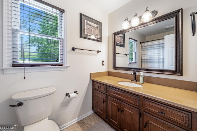full bath with toilet, vanity, baseboards, and tile patterned flooring