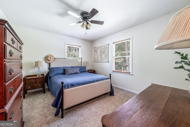 bedroom with multiple windows, carpet floors, a ceiling fan, a textured ceiling, and baseboards