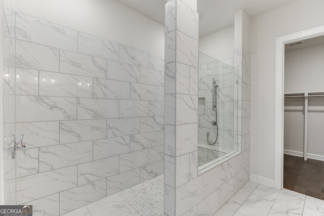 1023 Harvest Park Ln, Suwanee, GA 30024 - full bathroom featuring marble look tiles, walk in shower, a walk in closet, and baseboards