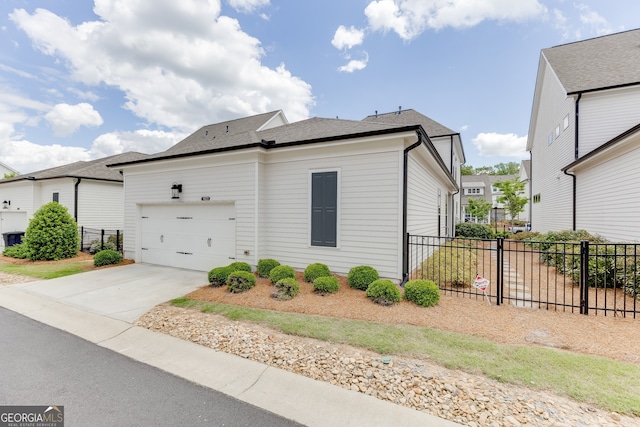 1023 Harvest Park Ln, Suwanee, GA 30024 - view of side of home with fence, an attached garage, driveway, and a shingled roof
